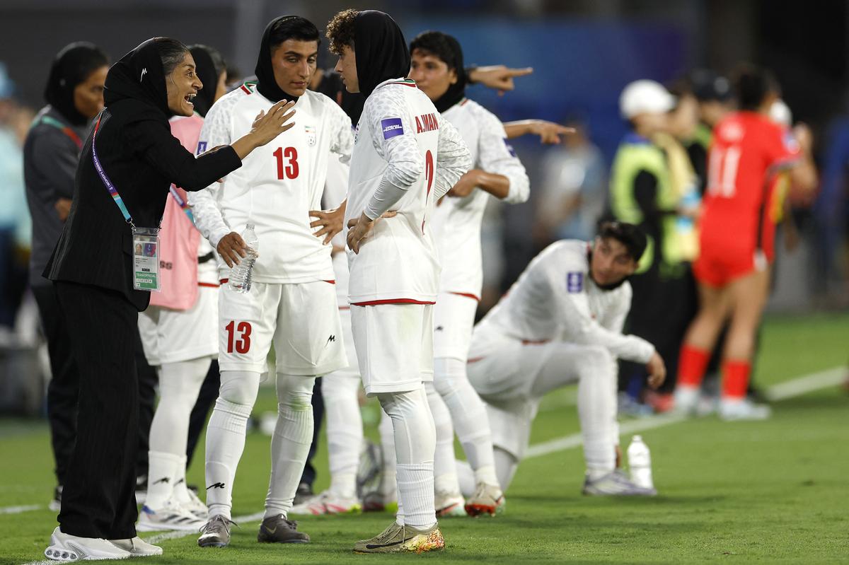 A técnica da seleção iraniana, Marzieh Jafari Baravati (à esquerda), dá instruções às jogadoras durante a partida da Copa Asiática Feminina da AFC de 2026 contra a Coreia do Sul.