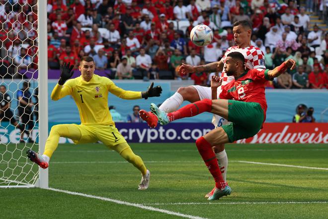 Pemain Maroko Youssef En-Nesyri beraksi di depan kiper Kroasia Dominik Livakovic pada pertandingan penyisihan grup, di awal turnamen.