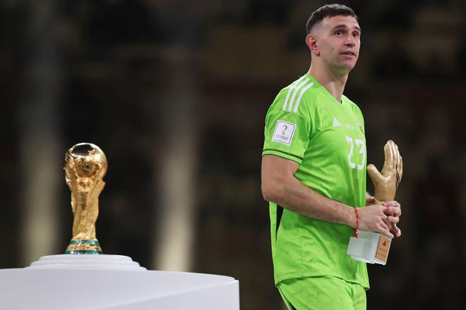 Emiliano Martinez of Argentina walks past the FIFA World Cup Qatar 2022 Winner’s Trophy after presented the Golden Glove trophy at the award ceremony following the FIFA World Cup Qatar 2022 Final match between Argentina and France at Lusail Stadium.
