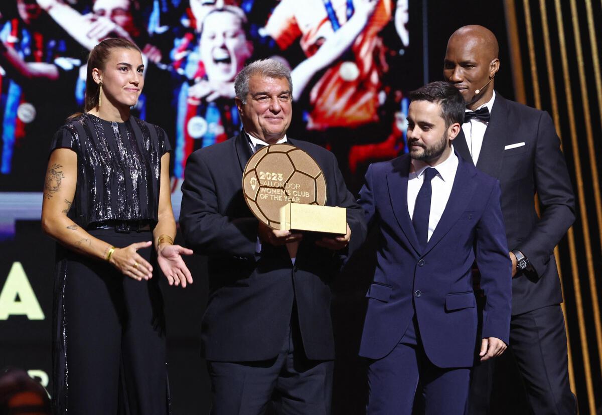  رئيس نادي برشلونة جوان لابورتا، ومدرب السيدات جوناتان جيرالديز وباتريشيا جويجارو مع جائزة أفضل نادي للسيدات خلال حفل توزيع الجوائز.
