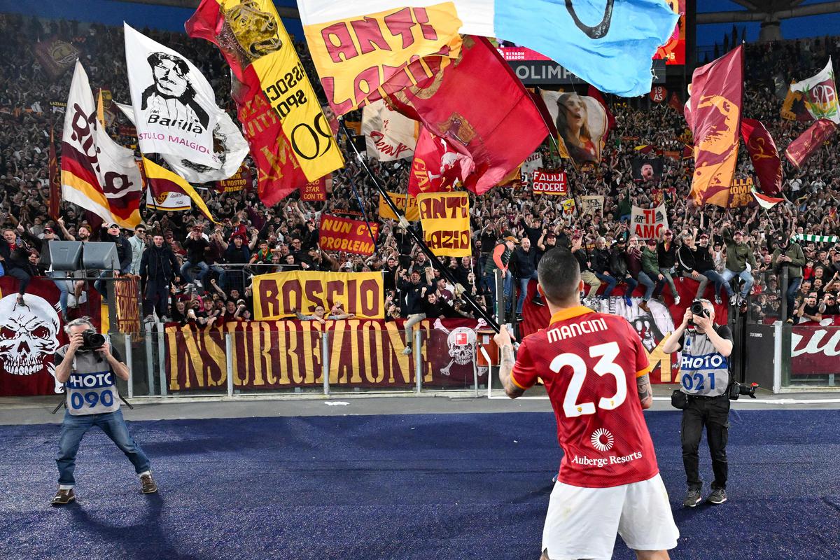 AS Roma’s Gianluca Mancini celebrates with fans after winning the match against Lazio.