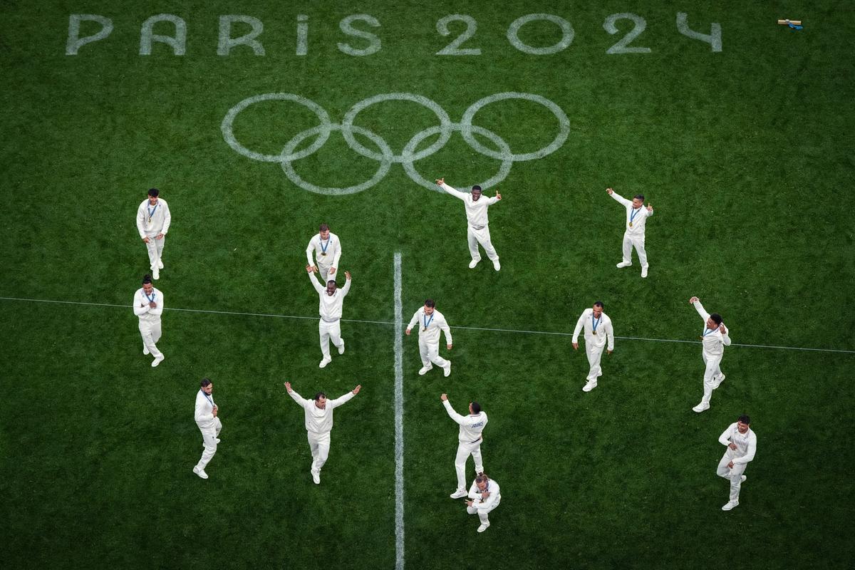 FILE PHOTO: French players dance on the pitch as they celebrate after beating Fiji in men’s rugby sevens final.