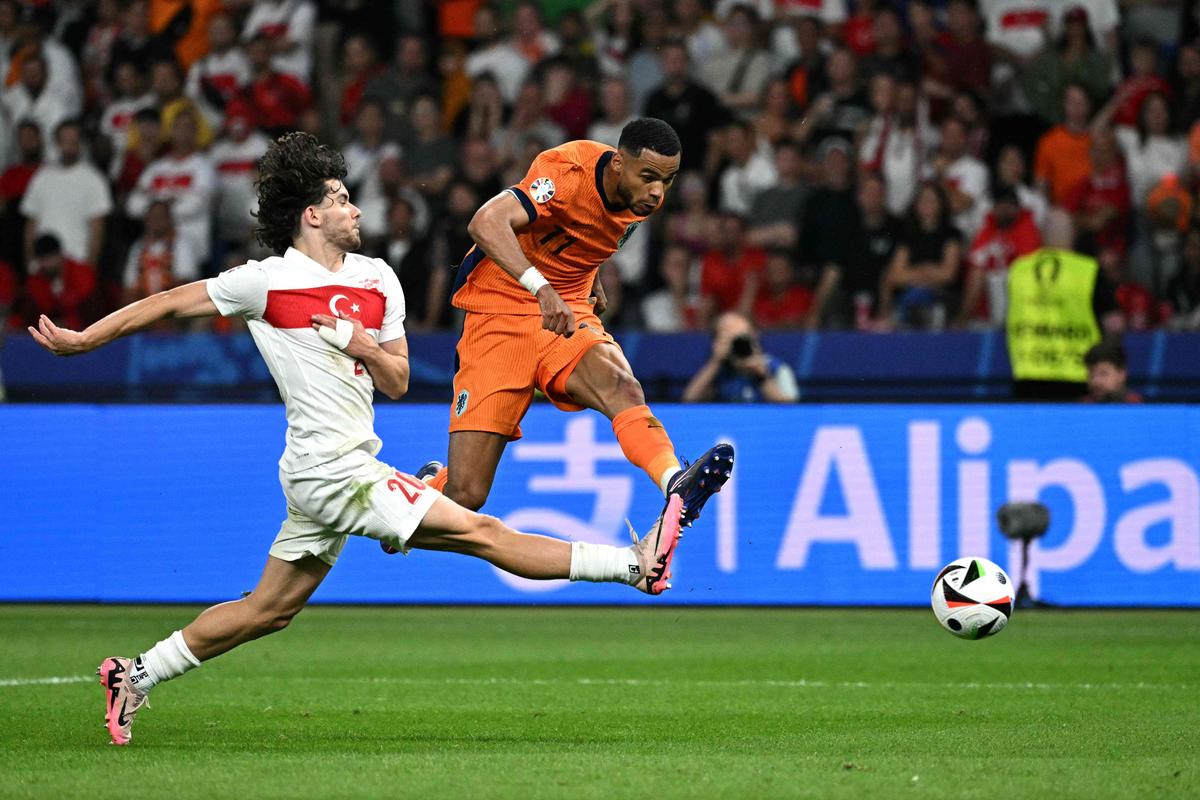 Netherlands’ forward Cody Gakpo (R) shoots to goal past Turkey’s defender Ferdi Kadioglu.