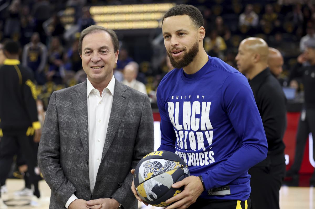 Stephen Curry, right, is presented with a 2024 NBA All-Star ball from Golden State Warriors team majority owner Joe Lacob.