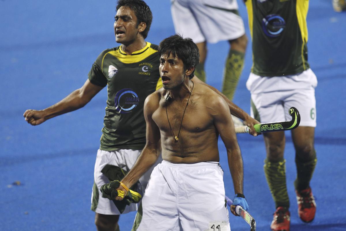 In this Saturday, December 13, 2014 photo, Pakistan’s Muhammad Tousiq, centre, takes off his shirt and gestures towards the crowd as his teammates celebrate their victory over India in the Champions Trophy semifinal in Bhubaneswar. The FIH, having investigated the matter, handed one-match bans to Tousiq and Ali Amjad following the 4-3 win. The international body had initially refused to take action despite terming the behavior as “beyond acceptable standards.”