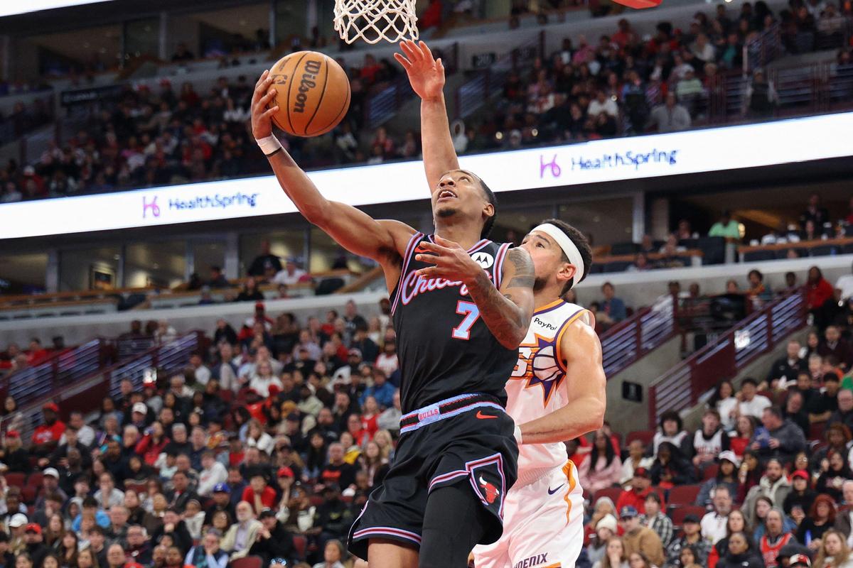 Rob Dillingham (7) of the Chicago Bulls attempts a layup against Devin Booker (1) of the Phoenix Suns. Rob Dillingham (7) of the Chicago Bulls attempts a layup against Devin Booker (1) of the Phoenix Suns.