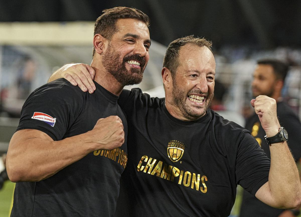 John Abraham (L), wwner of the NorthEast United FC, celebrates with coach Juan Pedro Benali after their team won the Durand Cup 2024.