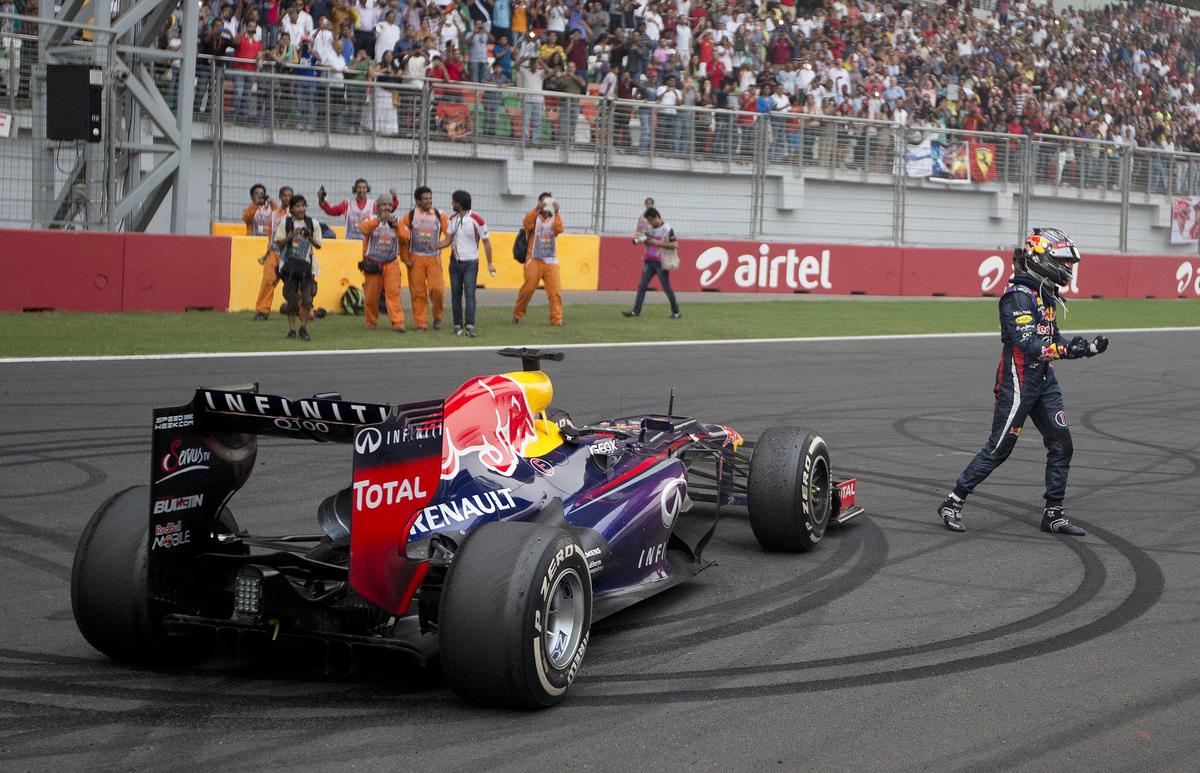 Red Bull driver Sebastian Vettel of Germany celebrates on the track after winning the Indian Formula One Grand Prix and his 4th straight F1 world championship at the Buddh International Circuit in Noida.