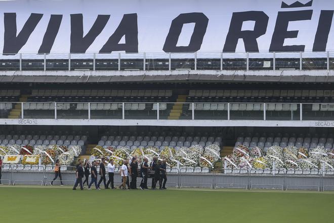 People, headed by son, Edinho, transport Pele’s coffin into the stadium.