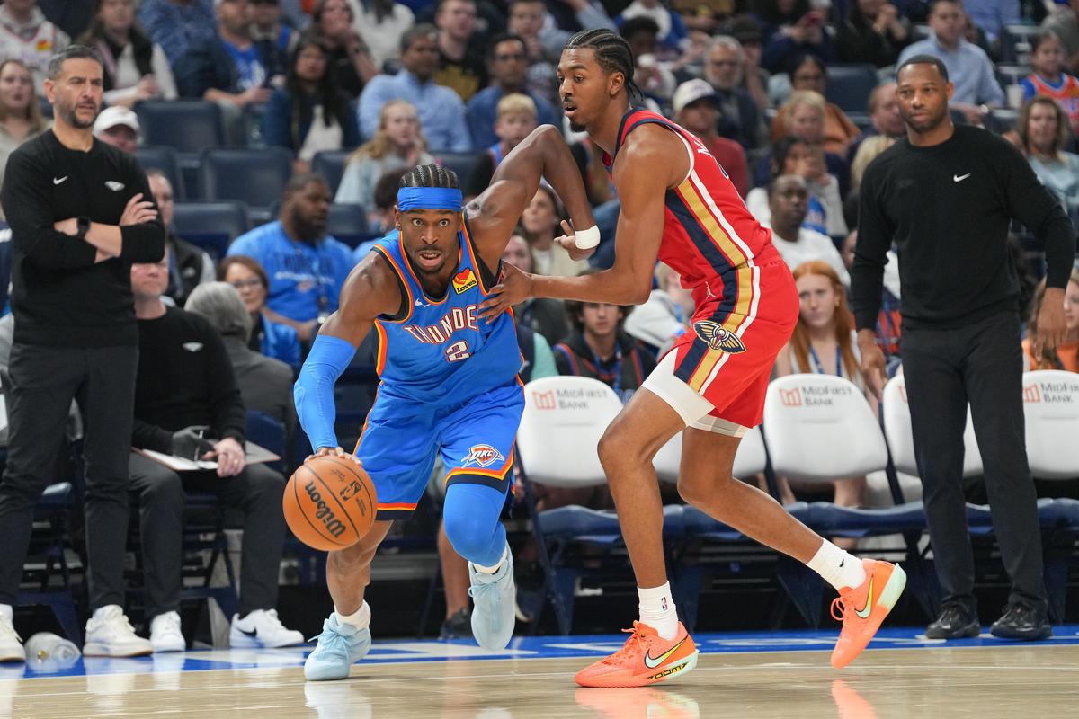 O armador do Oklahoma City Thunder, Shai Gilgeous-Alexander, dianteiro esquerdo, passa pelo atacante Trey Murphy III do New Orleans Pelicans. 