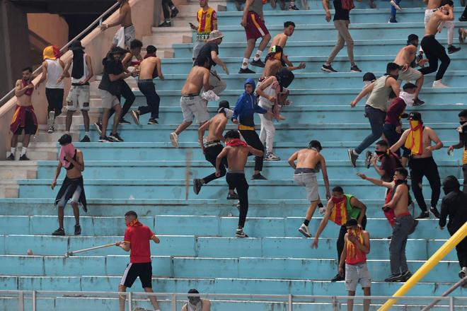 Esperance supporters run for cover during a fight with riot police during the CAF Champions League quarterfinal.