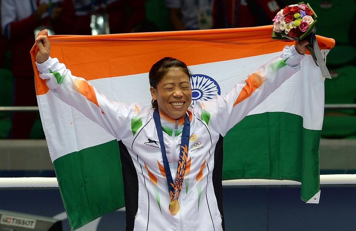 Gold medallist India’s Hmangte Chungneijang Mary Kom celebrates during the victory ceremony after winning the women’s flyweight (48-51kg) boxing final match against Kazakhstan’s Shekerbekova Zhaina during the 2014 Asian Games at the Seonhak Gymnasium in Incheon on October 1, 2014. 