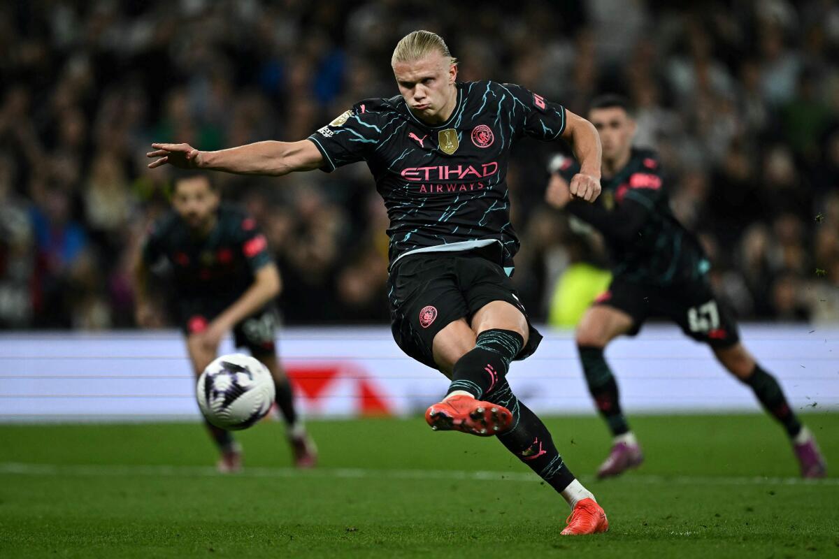 Erling Haaland shoots a penalty kick and scores his team’s second goal. 