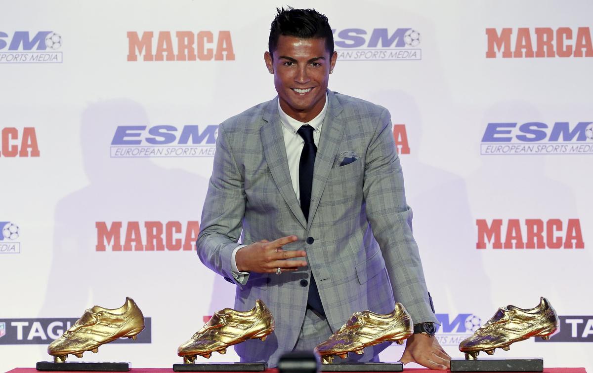 Real Madrid’s striker Cristiano Ronaldo poses in front of his four Golden Boot trophies during a ceremony in Madrid, Spain, October 13, 2015. 
