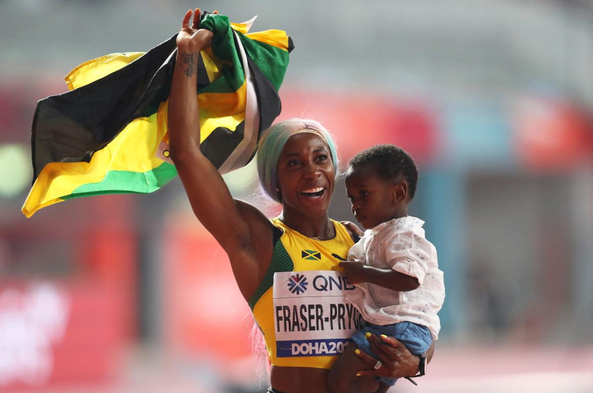 Shelly-Ann Fraser-Pryce celebrates with her son Zyon after winning the women's 100m gold at the World Athletics Championships at the Khalifa International Stadium on September 29, 2019 in Doha, Qatar. 