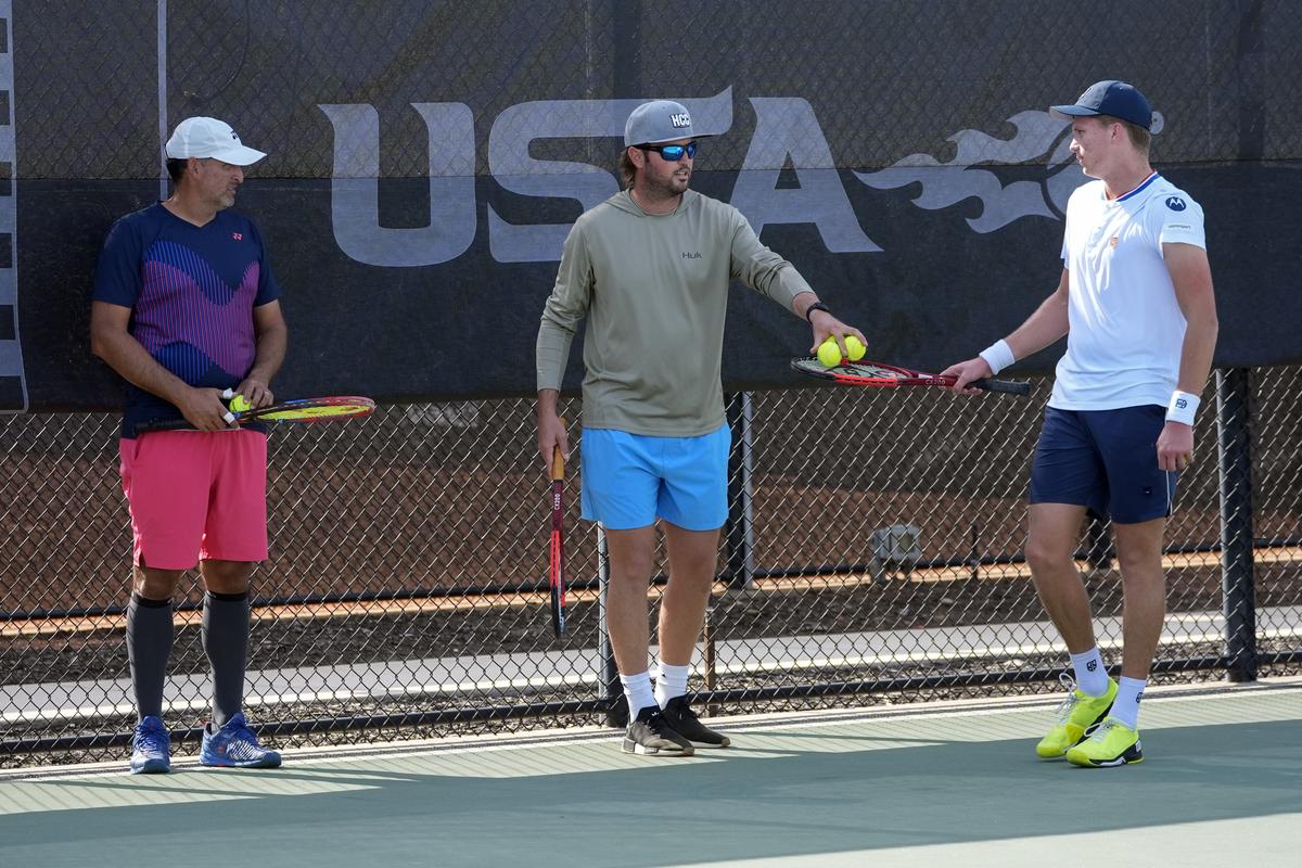 Tennis coaches Eric Nunez (left) and Rhyne Williams (center) work with Jenson Brooksby, (right) at the USTA national campus on Dec. 10 in Orlando.