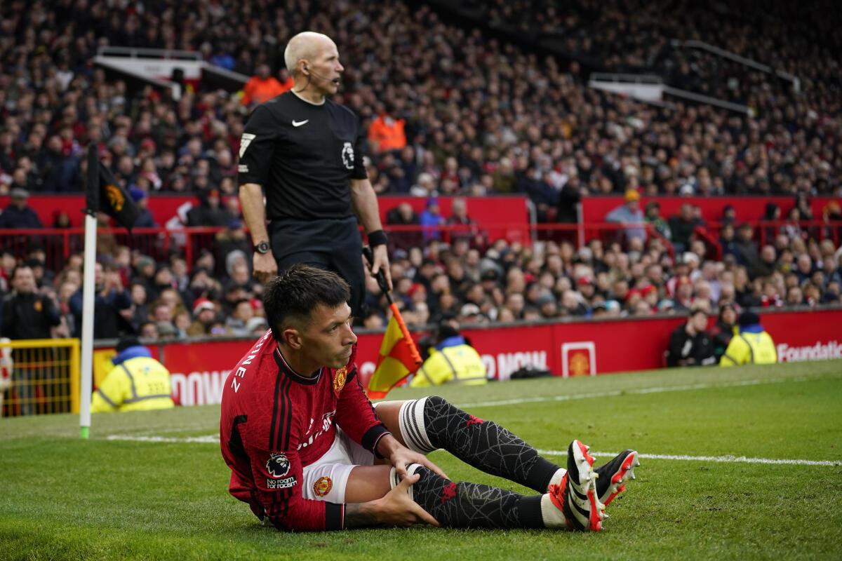 Manchester United’s Lisandro Martinez holds his knee after an injury during the English Premier League match between Manchester United and West Ham United at the Old Trafford stadium in Manchester, England, Sunday, Feb. 4, 2024.