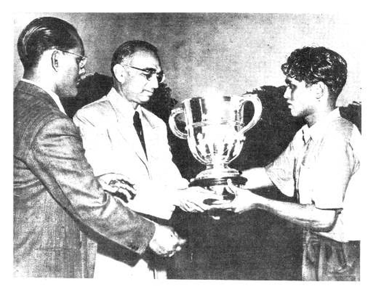 Venkatesh, captain of the East Bengal team, receiving the trophy from Mr. B. M. Patel, Defence Secretary, Government of India.