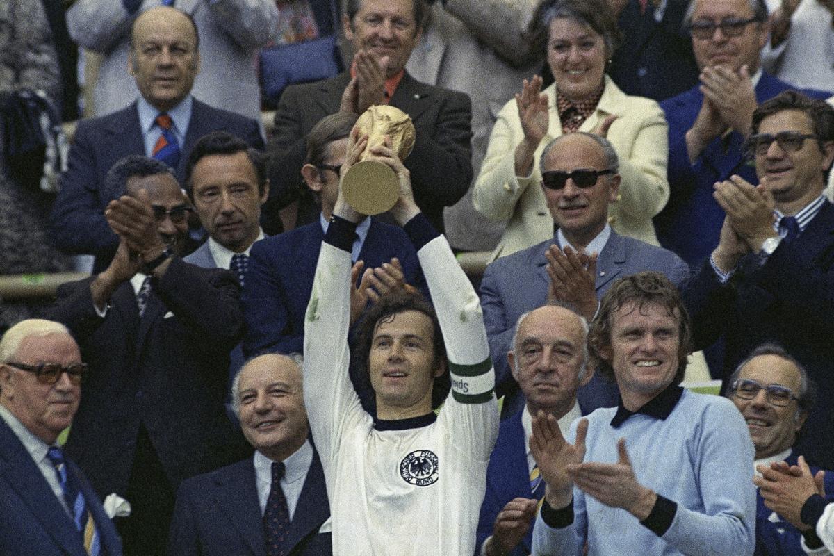 FILE - West Germany captain Franz Beckenbauer holds up the World Cup trophy after his team defeated the Netherlands by 2-1, in the World Cup soccer final at Munich’s Olympic stadium, in West Germany,  on Jul. 7, 1974. 