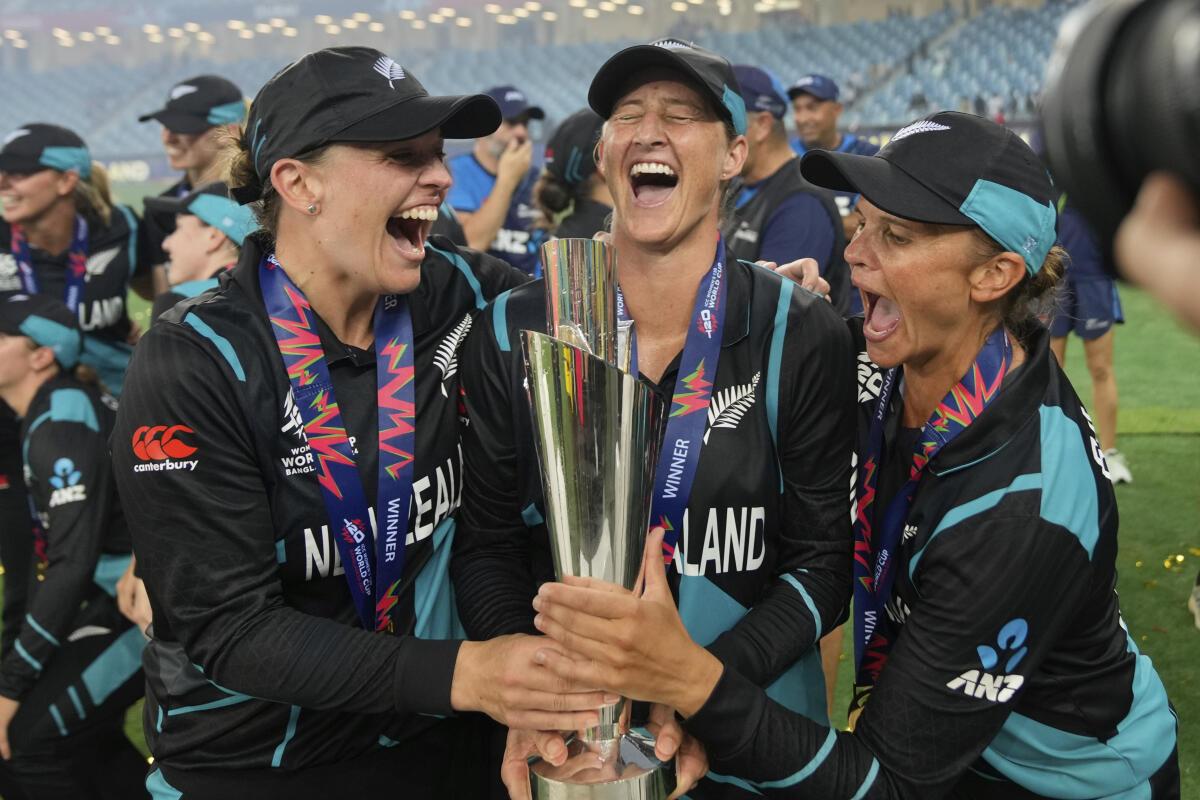 New Zealand‘s captain Sophie Devine, center, poses with teammates Lea Tahuhu, left, and Suzie Bates with the trophy after winning the ICC Women‘s T20 World Cup 2024.