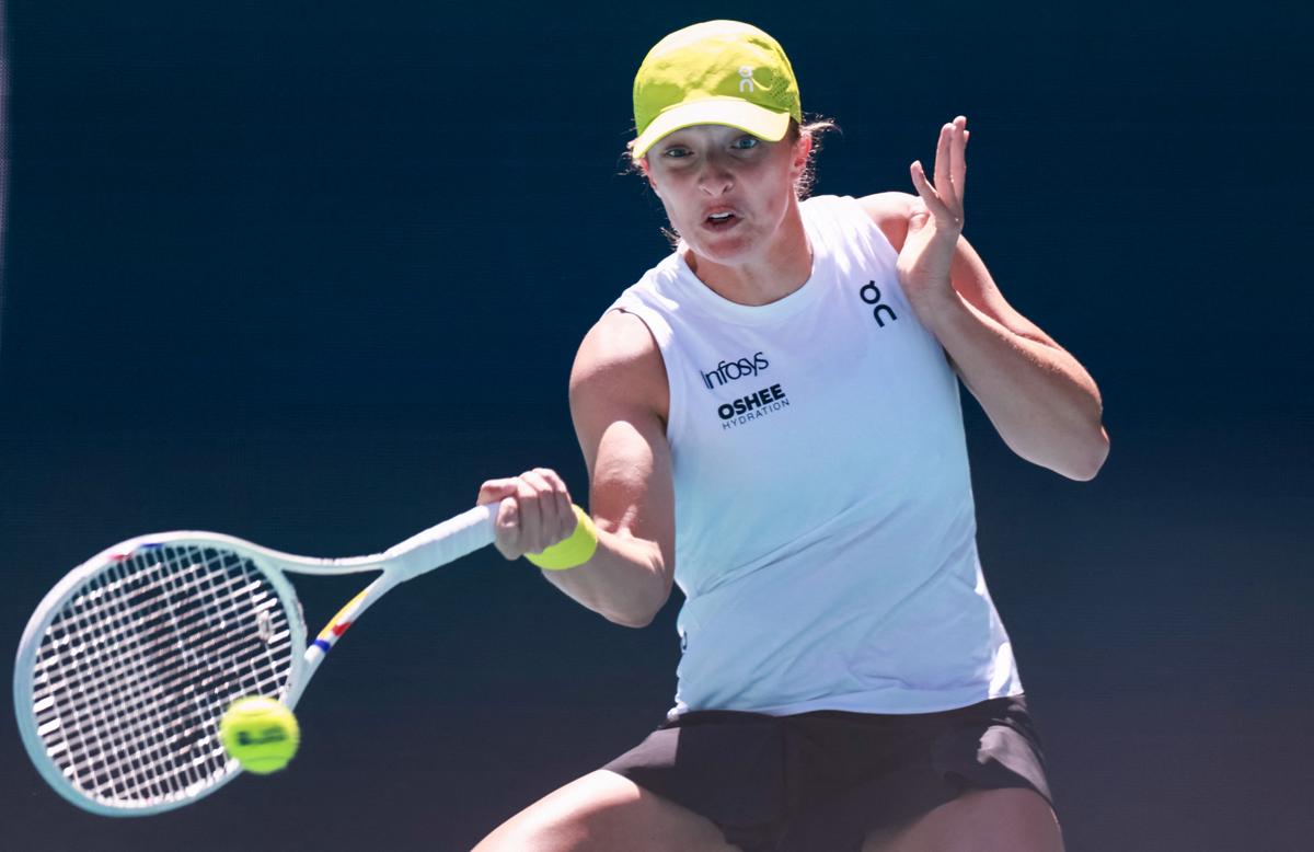 Iga Swiatek of Poland returns a shot against Caroline Garcia of France during their Miami Open match at Hard Rock Stadium.