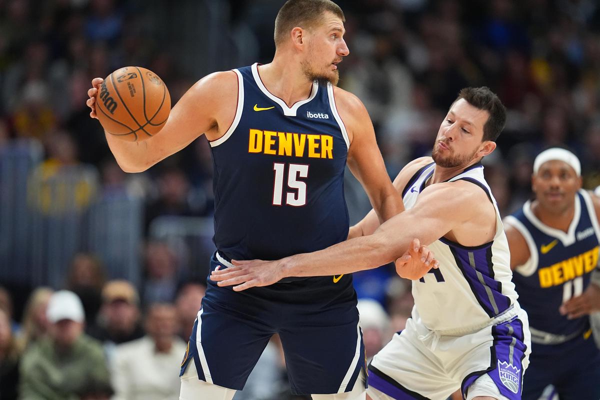 Denver Nuggets center Nikola Jokic, left, looks to pass the ball as Sacramento Kings forward Drew Eubanks defends. 