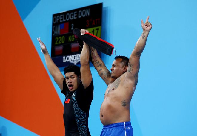 Don Opeloge of Samoa (left) celebrates with his coach after winning the gold in the Men’s 96kg weightlifting final on Tuesday. 