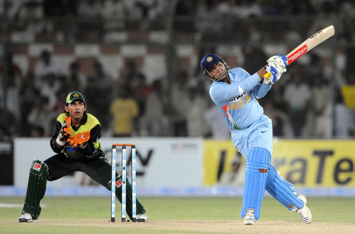 Virender Sehwag hits a six as Pakistan wicketkeeper Sarfaraz Ahmed looks on during a Group B at the National Cricket Stadium in Karachi on June 26, 2008. 