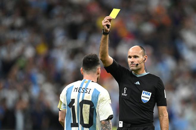 Referee Antonio Mateu shows a yellow card to Lionel Messi of Argentina during the FIFA World Cup Qatar 2022 quarter final match between Netherlands and Argentina at Lusail Stadium on December 09, 2022 in Lusail City, Qatar.