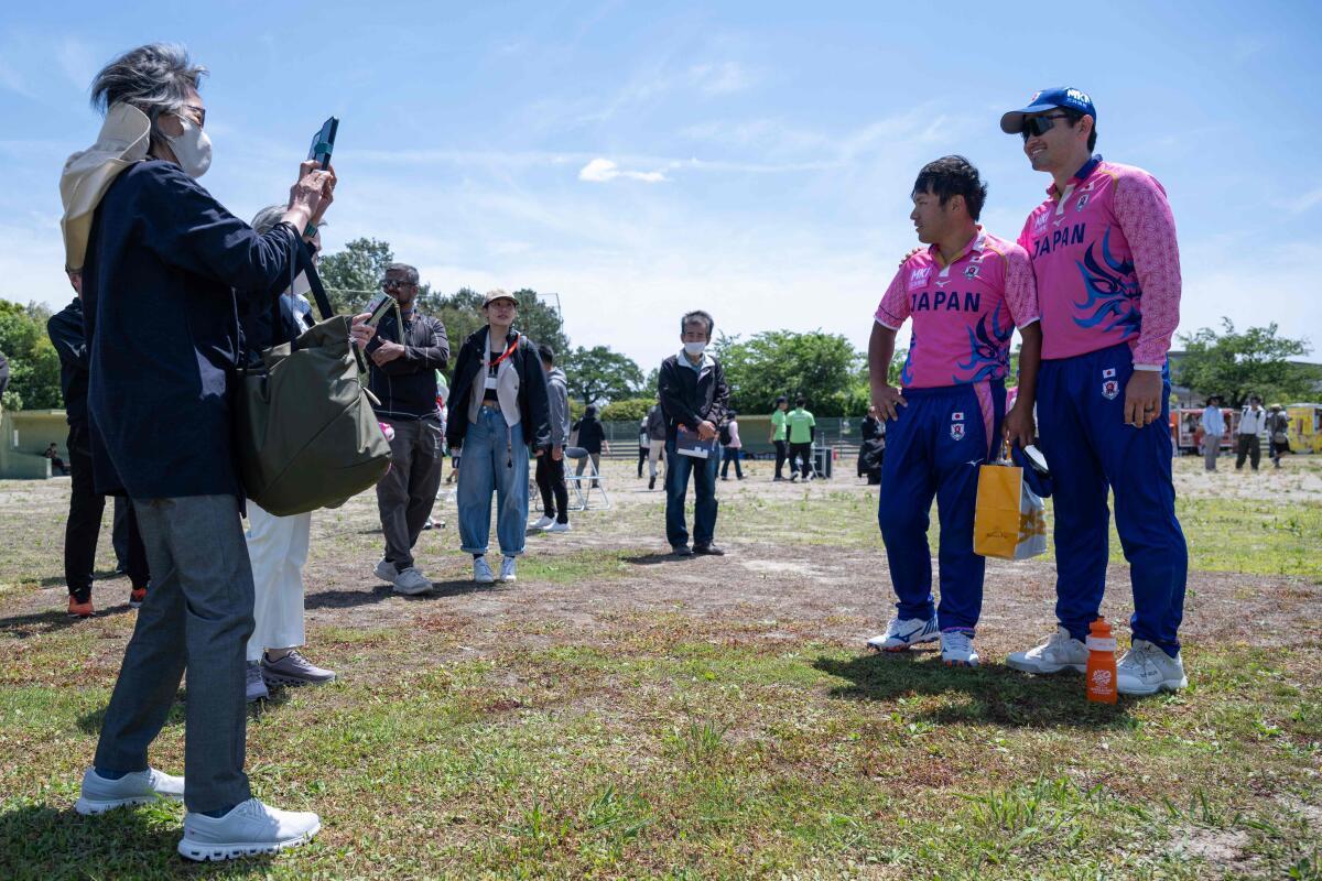 Los aficionados toman una fotografía de los miembros del equipo nacional de cricket de Japón después del partido de clasificación para la Copa Mundial ICC T20 de Asia Oriental y el Pacífico contra Vanuatu.
