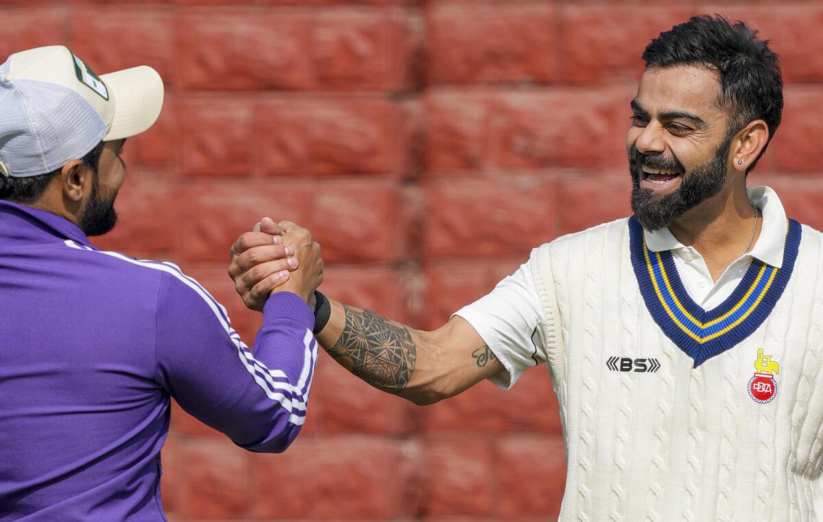 Virat Kohli shares a light moment with his former cricket mate Shawej Khan during a training session ahead of the Ranji Trophy 2024-25 cricket match between Delhi and Railways.