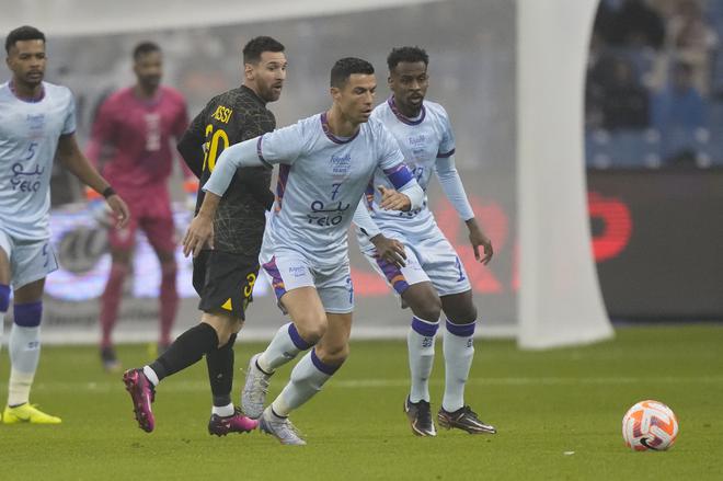 Cristiano Ronaldo, right, playing for a combined XI of Saudi Arabian teams Al Nassr and Al Hilal, is challenged by PSG’s Lionel Messi. 