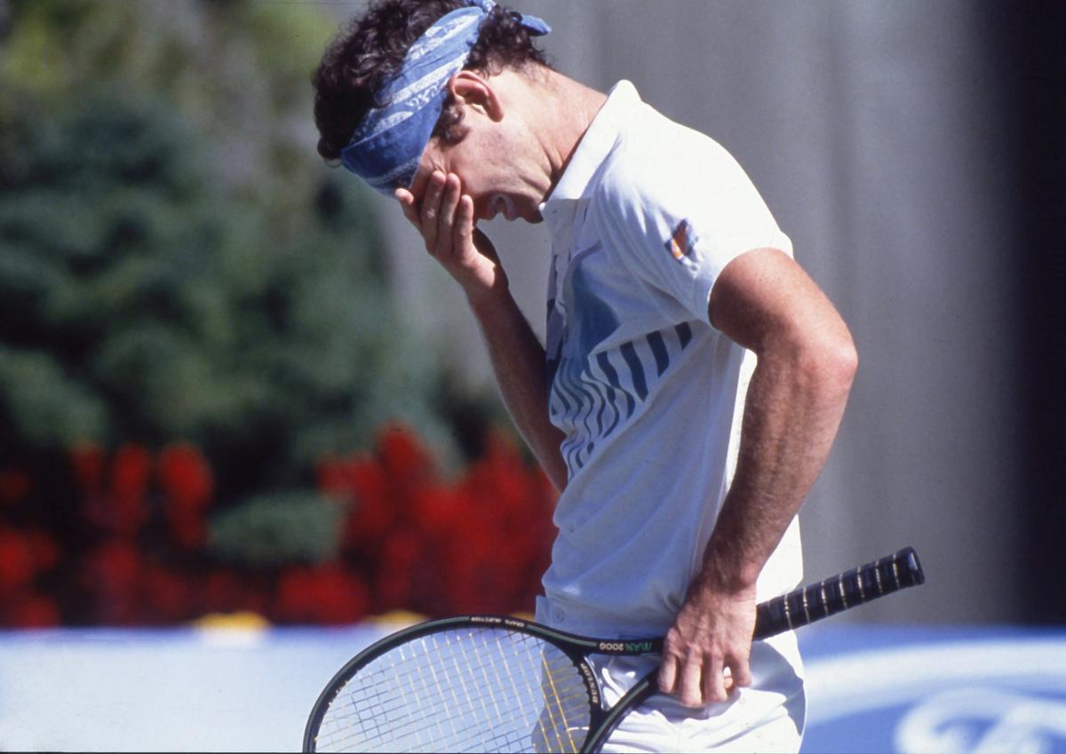 John McEnroe covers his face after disqualification by the umpire during the Australian Open in Melbourne in January 1990.