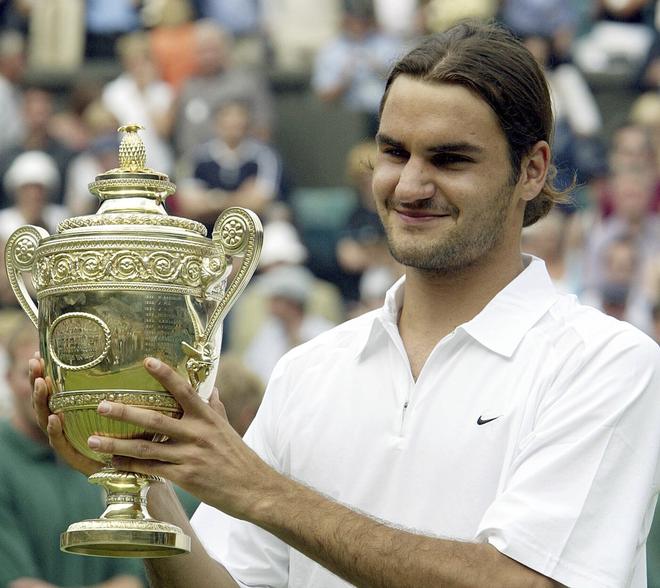 The beginning: Federer holds the men;s singles trophy after defeating Australia’s Mark Philippoussis in the Wimbledon final for his first Grand Slam.