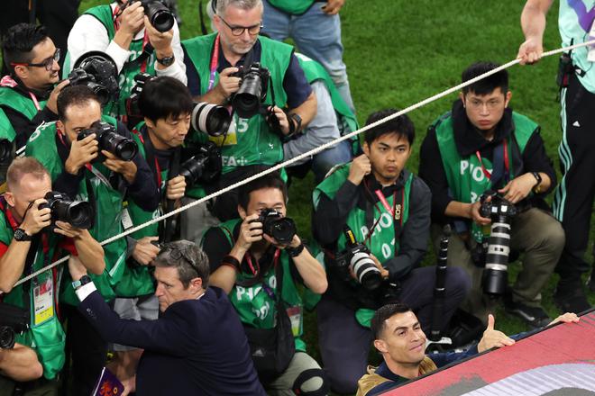 Cristiano Ronaldo is seen on the bench while photographers takes pictures of him before the FIFA World Cup Qatar 2022 quarterfinal match between Morocco and Portugal at Al Thumama Stadium.