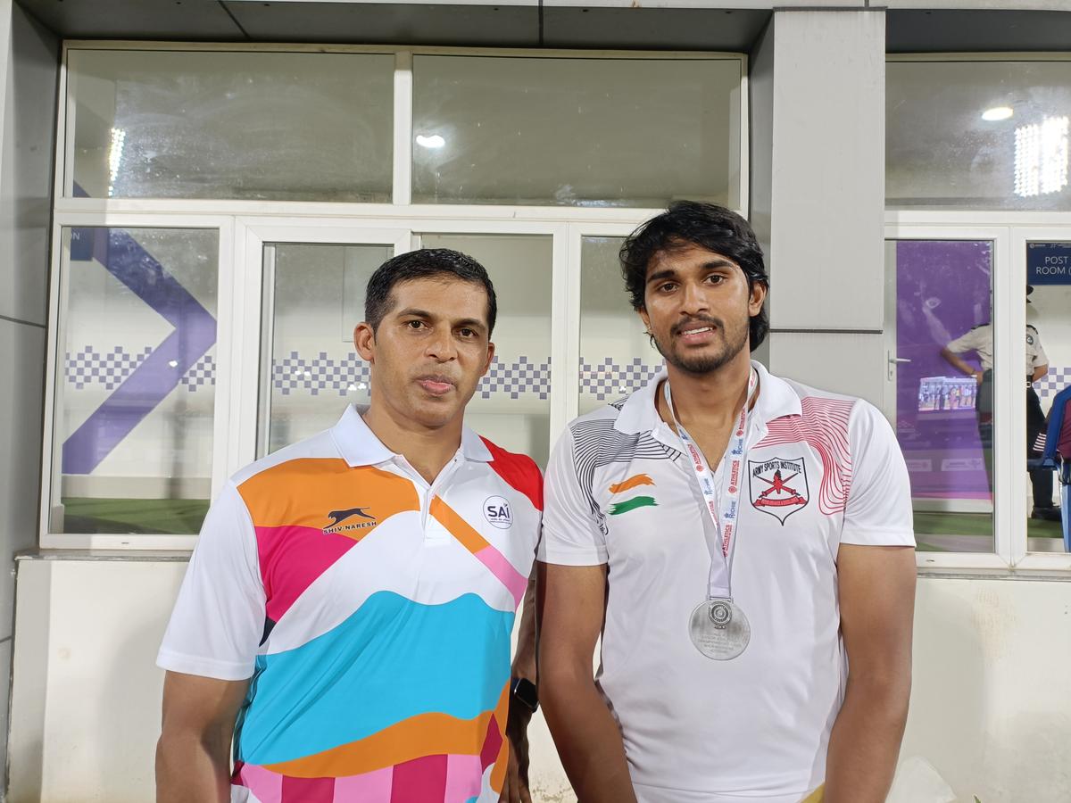 Karnataka’s Manu DP (right), silver medallist in men’s javelin throw, along with his coach Kashinath Naik (left) during the 27th Federation Cup at the Kalinga Stadium in Bhubaneswar on Wednesday.