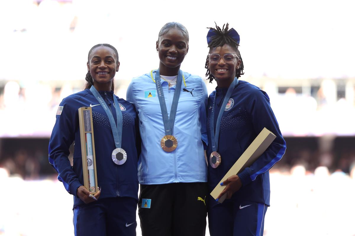 Julien Alfred (C) of Saint Lucia, Sha’Carri Richardson (L) and Melissa Jefferson (R) of United States celebrate on the podium during Women’s 100m medal ceremony on day nine of the Olympic Games Paris 2024.