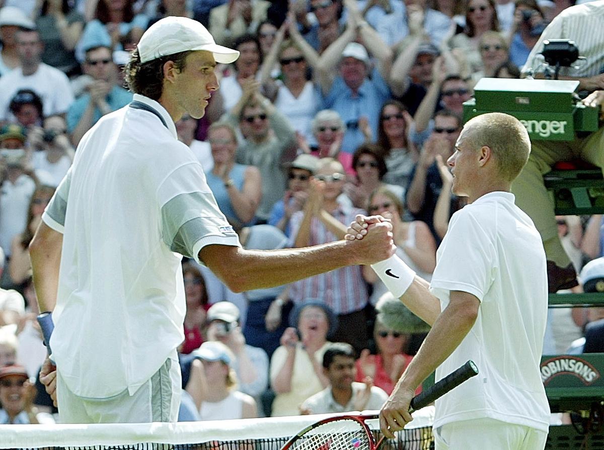 Australia’s Lleyton Hewitt (right) shakes hands with Croatia’s Ivo Karlovic (left) after defeat in first round of Wimbledon on June 23, 2003. 