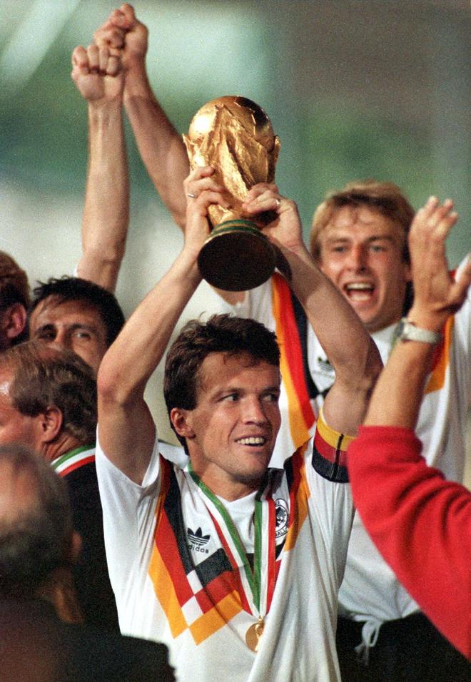 West Germany's national soccer team captain Lothar Matthaeus (C), holds aloft  the World Cup trophy as he celebrates with teammate Juergen Klinsmann (R) after  West Germany beat Argentina 1-0 in the World Cup final 08 July 1990 at the Olympic stadium in Rome.  AFP/EPA/DPA/ FRANK KLEEFELDT