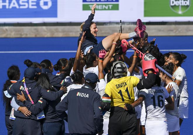 Indian players celebrate their win over New Zealand with coach Janneke Schopman after the women’s bronze medal hockey match on Sunday. 