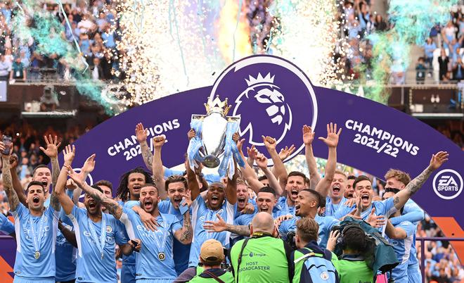 Manchester City captain Fernandinho lifts the Premier League trophy and celebrates with the squad. 
