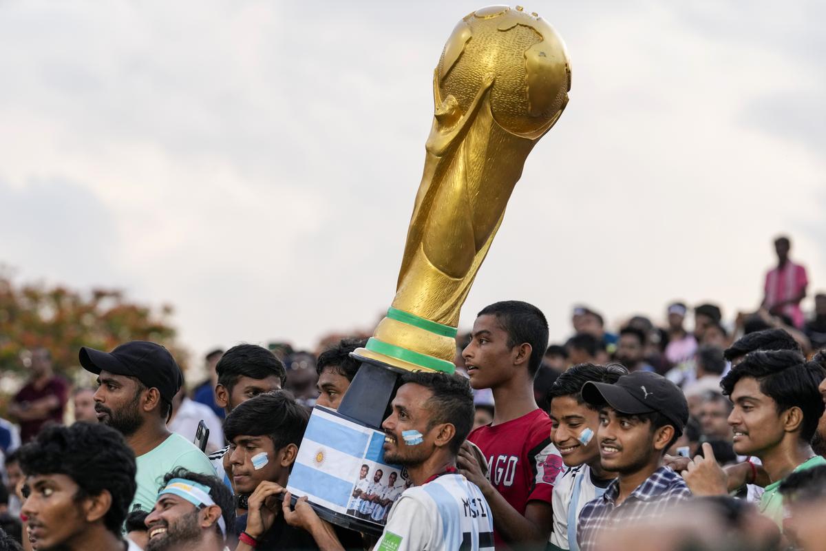 Fans carrying a replica of FIFA World Cup as they wait for Emiliano Martinezto arrive.