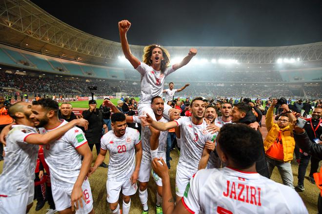 Tunisia’s players celebrate qualifying for the 2022 Qatar World Cup African Qualifiers football match between Tunisia and Mali at the Hamadi Agrebi Olympic stadium in the city of Rades on March 29, 2022. - Tunisia secured a place at the 2022 World Cup in Qatar despite being held 0-0 at home by Mali in the second leg of an African play-off. 