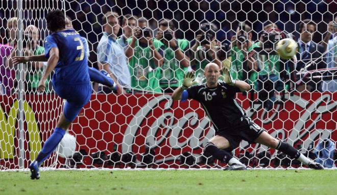 Italian defender Fabio Grosso (L) shoots the winning penalty against French goalkeeper Fabien Barthez during the World Cup 2006 final football game Italy vs.France, 09 July 2006 at Berlin stadium.