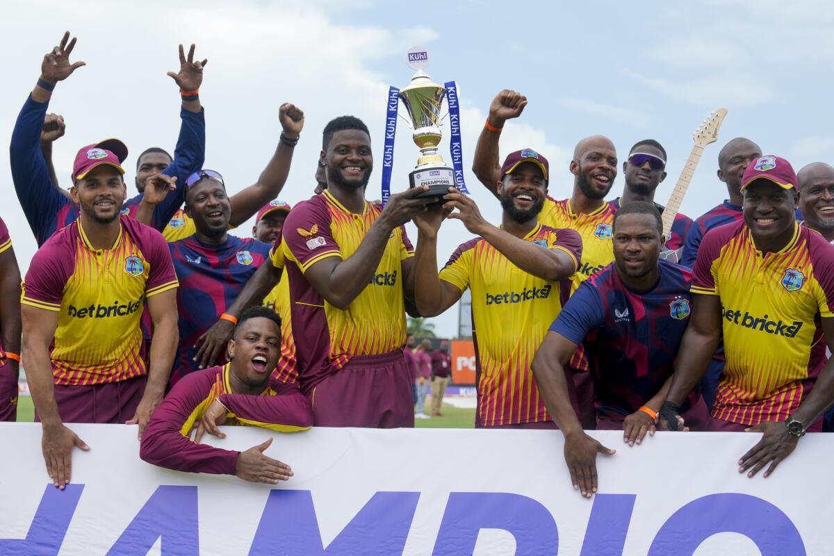 Players of West Indies celebrate with the trophy after beating India in the fifth and last T20 cricket match. 