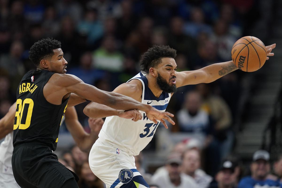 Utah Jazz guard Ochai Agbaji (30) and Minnesota Timberwolves center Karl-Anthony Towns (32) reach for the ball during the second half of an NBA basketball game Thursday, Nov. 30, 2023, in Minneapolis. 