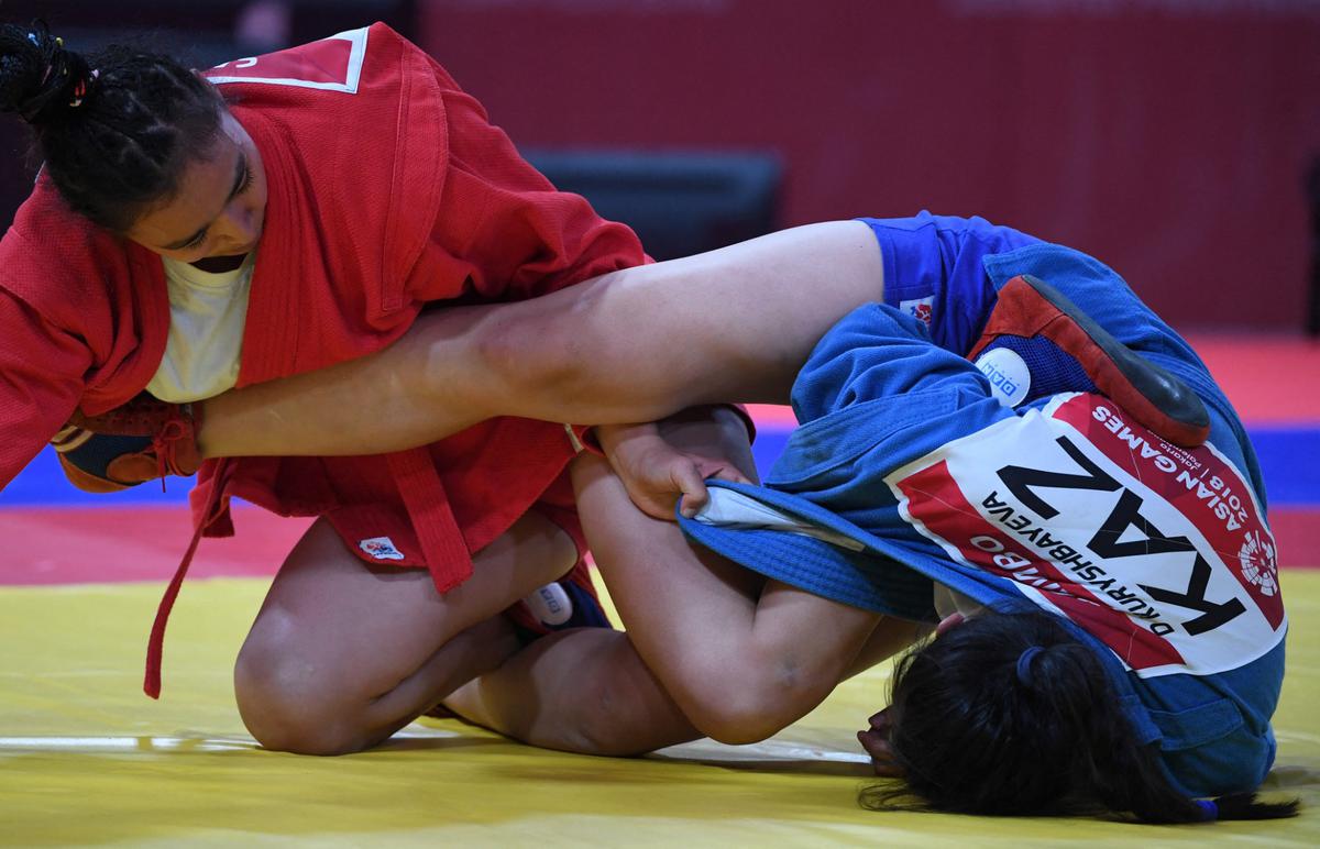 Dildash Koreshbayeva (biru) dari Kazakhstan dan Nilufar Davletova (merah) dari Uzbekistan bertarung pada final sambo 68kg putri di Asian Games 2018.