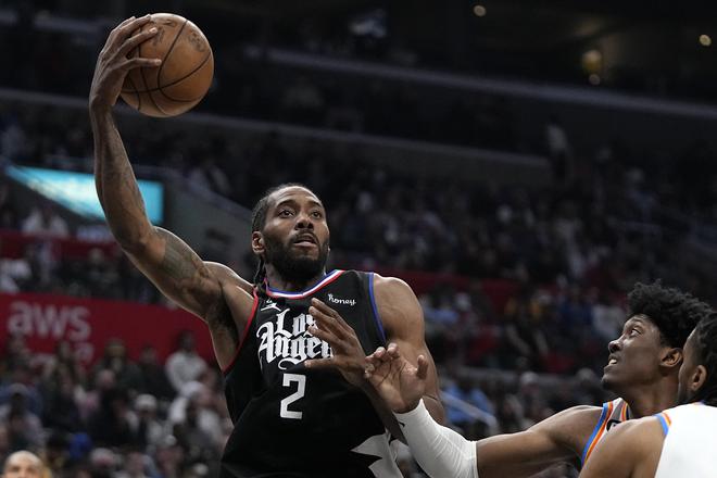 LA Clippers forward Kawhi Leonard, left, shoots as Oklahoma City Thunder forward Jalen Williams defends during the second half of an NBA basketball game.