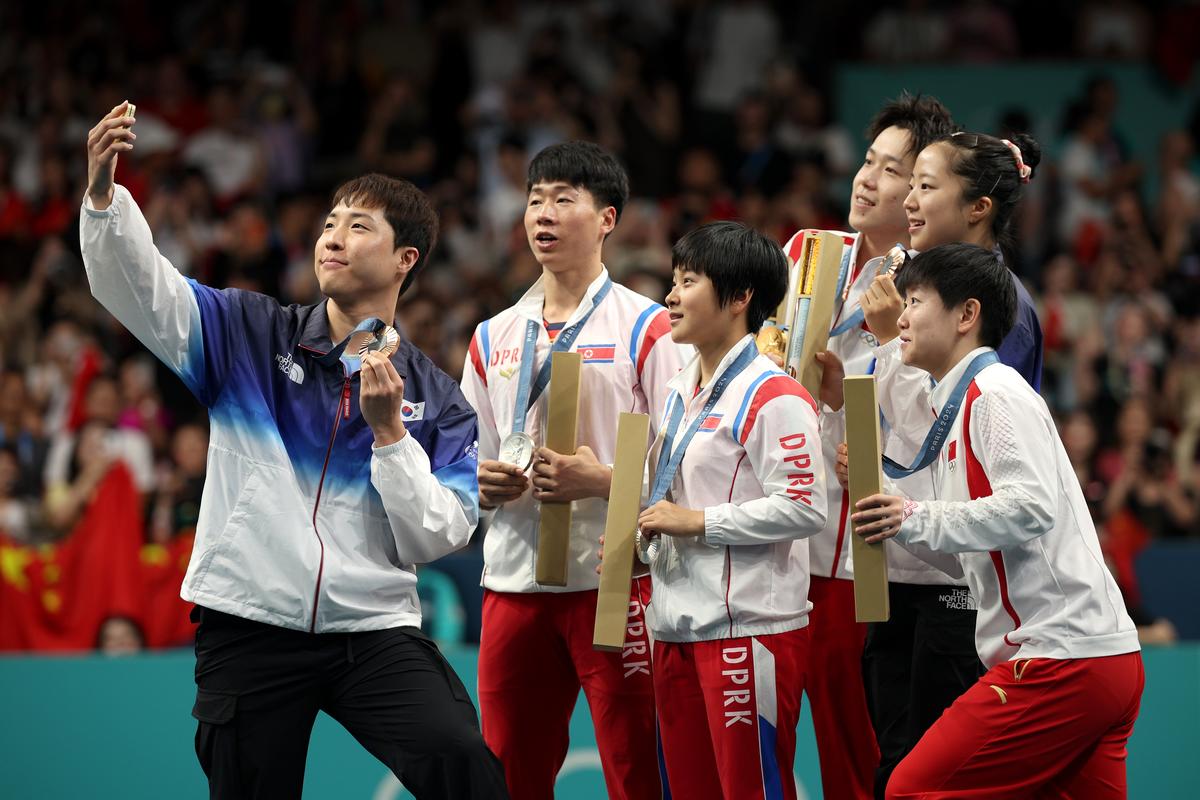 Silver medalist Jonghoon Lim of Team Republic of Korea takes a selfie with gold medalists Chuqin Wang and Yingsha Sun of Team Democratic People’s Republic of Korea and bronze medalist Jong Sik Ri and Kum Yong Kim of Team Democratic People’s Republic of Korea after the Table Tennis Mixed Doubles on day four of the Olympic Games Paris 2024 at South Paris Arena on July 30, 2024 in Paris, France.