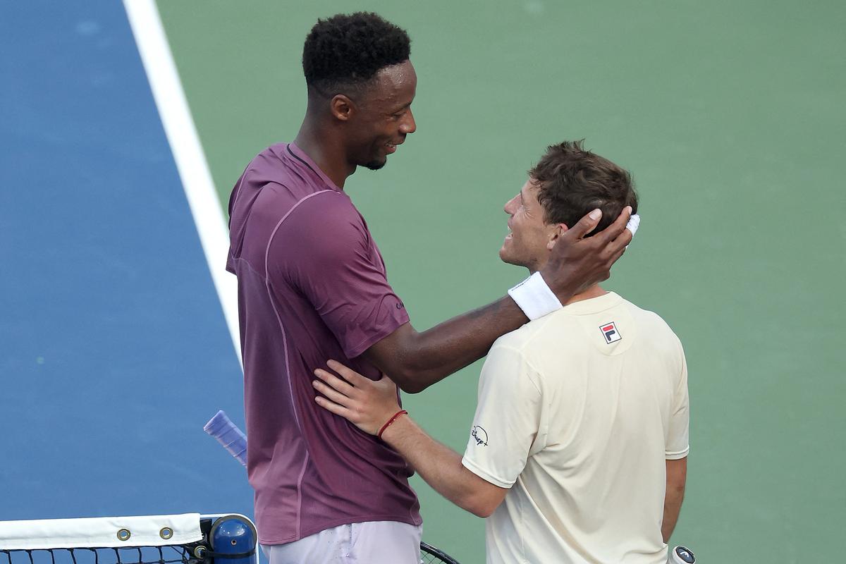 Gael Monfilstalks with Diego Schwartzman after their US Open match on Monday.